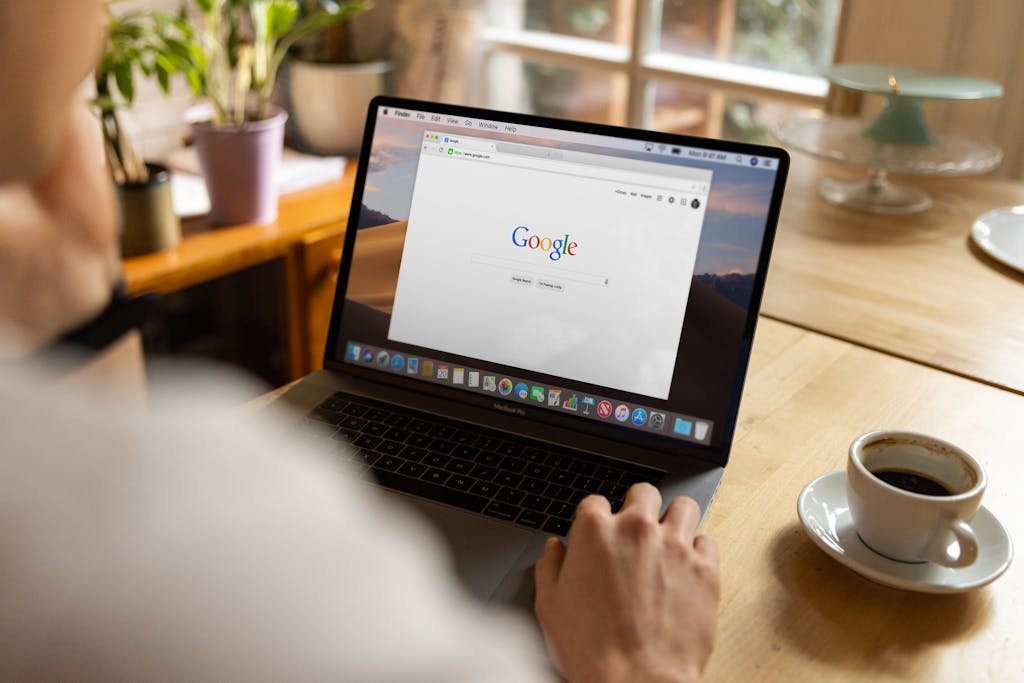 ein Erwachsener sitzt in einem Kaffee und sucht auf Google nach etwas.